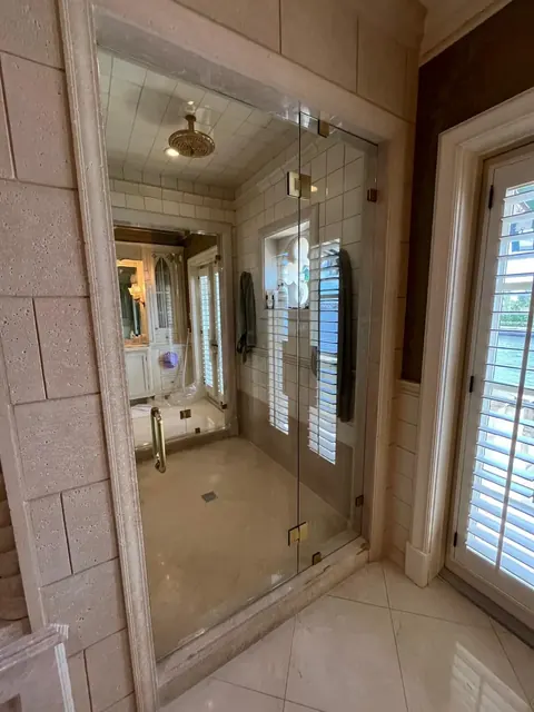 Sliding glass shower door with gold hardware