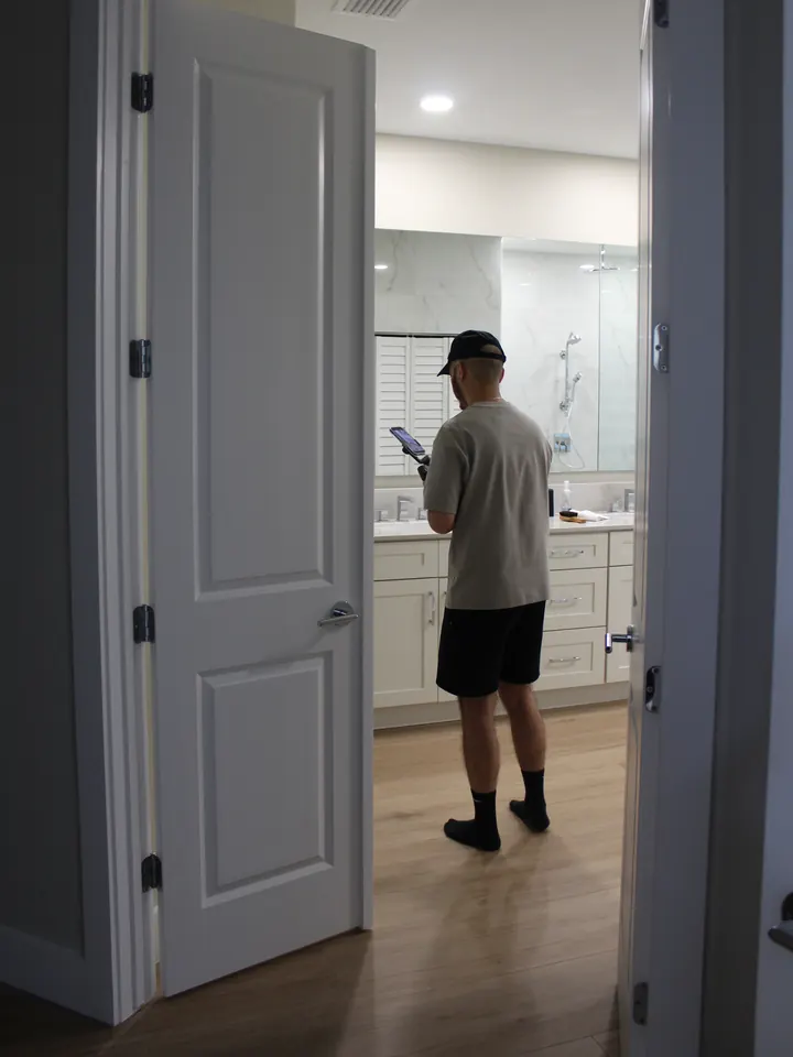 Daniel filming a finished bathroom with a phone on a gimbal