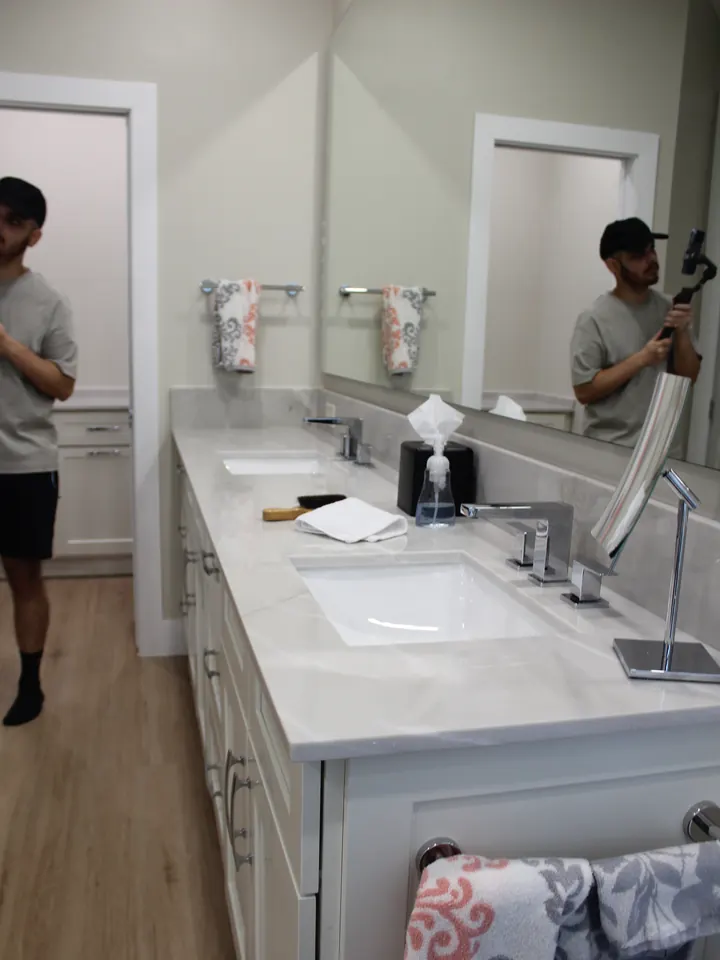 Daniel filming a double vanity, seen in the mirror